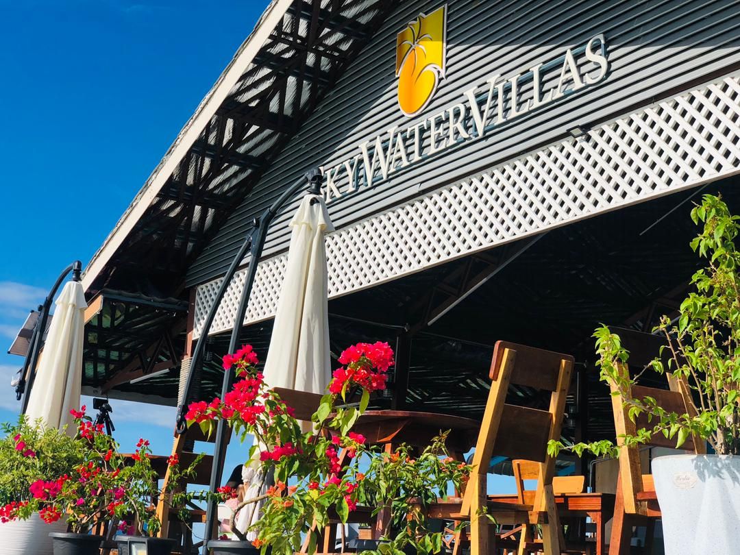 A building with a sign reading 'KWATERVILLAS' and a logo above it.