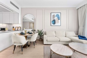 Ein modernes Wohnzimmer mit einer Couch, einem Esstisch, Stühlen und einem Couchtisch.