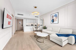 Ein modernes Wohnzimmer mit einer Couch, einem Couchtisch und einem Essbereich mit Stühlen und einem Tisch.
