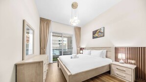 A hotel room with a bed, bedside table, lamp, and a large window with curtains. - StayShort - Chic 1BR Sleeps 2 in Dubai Marina Near Metro (Dubai Marina)