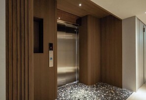 An elevator with a control panel, wooden paneling, and a terrazzo floor. - Papo'a Labs (Tainan)