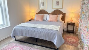 Une chambre à coucher avec un lit, des lampes de chevet, un tapis et une fenêtre.