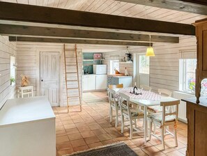 Un interior rústico con comedor, cocina y un altillo.