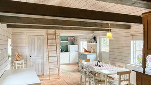 Ein rustikales Interieur mit Essbereich, Küche und einer Schlafempore.