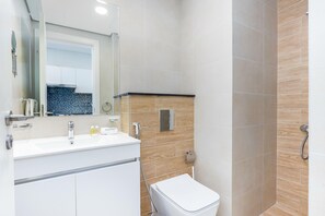 Ein modernes Badezimmer mit Waschbecken, Spiegel und Toilette in Weiß.