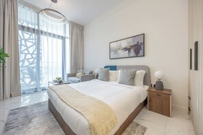 Ein modernes Schlafzimmer mit einem großen Bett, einem Nachttisch, einer Lampe und einem Bild an der Wand.