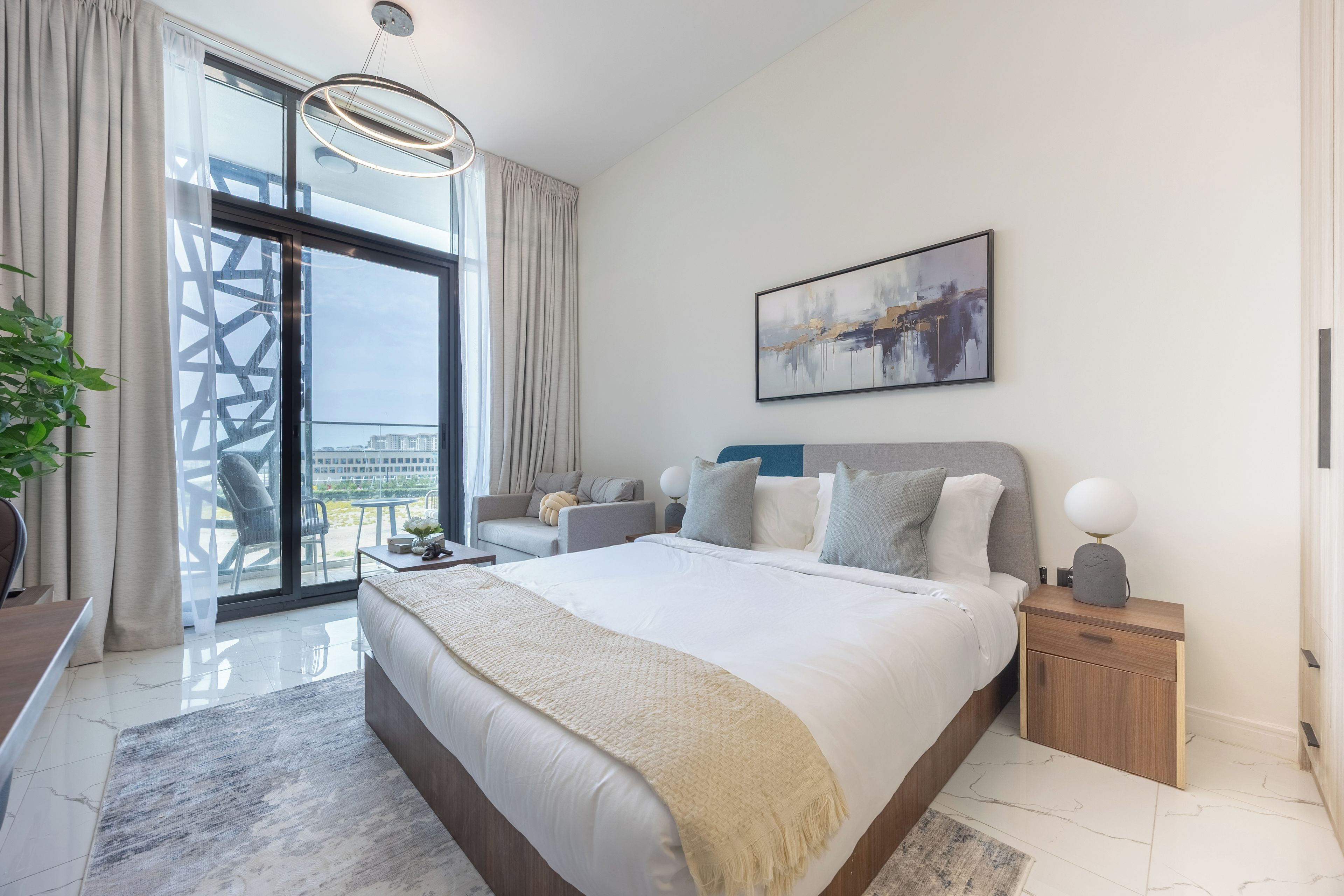A modern bedroom with a large bed, a view of the city, and a balcony.