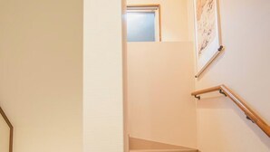 A staircase with carpeted steps, a handrail, and a framed picture on the wall. - 福助Hakuro   double bath; 5mins to Metro;Nipponbashi Namba7mins;Nara direct (大阪市 東成区　大今里西 3-13-10)