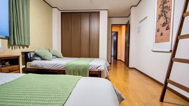 A hotel room with two beds, a wardrobe, a desk, and a painting on the wall. - 福助Hakuro   double bath; 5mins to Metro;Nipponbashi Namba7mins;Nara direct (大阪市 東成区　大今里西 3-13-10)