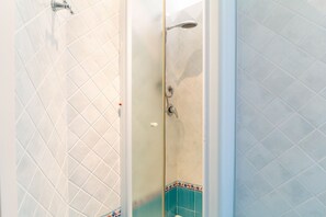 Een douche, een bidet, handdoeken, shampoo