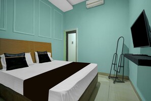 A hotel room with a bed, a television, and a door. - Hotel O near Primaya Hospital formerly  (Makassar)