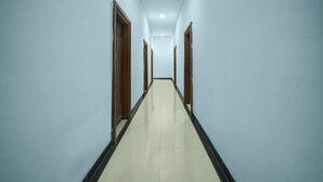 Un long couloir étroit, doté d’un sol carrelé et de murs bleu clair.