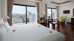 Een hotelkamer met een groot bed, een bureau, een stoel en een televisie.