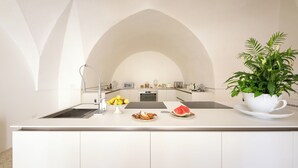 Une cuisine moderne dotée d’un îlot central, de meubles blancs et d’une grande fenêtre en arc de cercle.