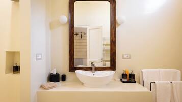 A bathroom with a white sink, a large mirror, and a towel rack.
