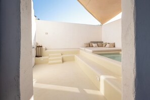 A spa area with a hot tub, seating, and steps leading to the tub. - Villani Lubelli Apartments (Cannole)