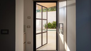 Un couloir moderne avec une porte en verre donnant sur un espace patio.