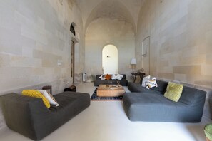 A spacious living room with two grey sofas, a wooden coffee table, and a patterned rug. - Villani Lubelli Apartments (Cannole)