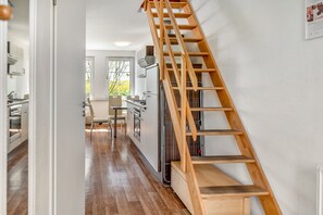 Una cocina moderna con una escalera de madera que sube a un nivel superior.