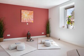 A room with a red wall, a window with a view, and a decorative lantern.