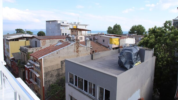 A multi-story building with a rooftop terrace, visible windows, and a clear sky. - Laos Otel & Apartment (Istanbul)