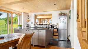 Una cocina moderna con una isla grande, techo de madera y vistas al exterior.