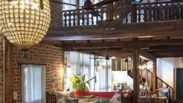 A spacious interior with a high ceiling, a balcony, a seating area with red cushions, and a dining table. - Amã Stays & Trails L'attitude By The Lake, Kamshet (Mawal)