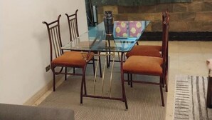 A dining area with a glass table and wooden chairs. -  Entire rental, Perfect Abbass el akkad flat with balcony (cairo)