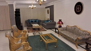Un salon avec deux canapés, une table basse, un lustre et une lampe décorative.