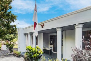A building with a flag, columns, and a door. - OYO Homes 91118 Homesstay Desa Wisata Budo Near Desa Wisata Budo (Wori)