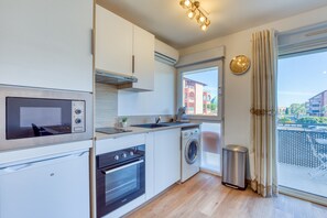 Eine moderne Küche mit integrierten Geräten, einem Fenster mit Ausblick und einem Balkon.
