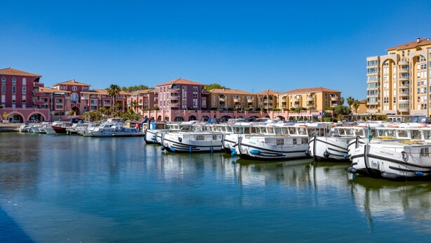 A marina with multiple boats docked, surrounded by multi-story buildings with balconies. - Cosy Renovated Apartment Near the Beach With Balcony (Lattes)
