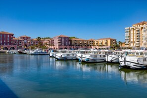 A marina with multiple boats docked, surrounded by multi-story buildings with balconies. - Cosy Renovated Apartment Near the Beach With Balcony (Lattes)
