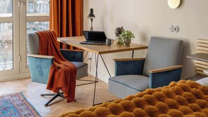 A modern room with a desk, two chairs, a large mirror, and a window with curtains. - Sunny Apartment in the Center | Place to Work (Warszawa)