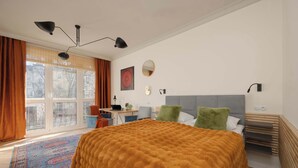 A bedroom with a large bed, a desk, a chair, and a window with curtains. - Sunny Apartment in the Center | Place to Work (Warszawa)