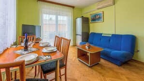 Ein Essbereich mit einem Holztisch, Stühlen und einem blauen Sofa.