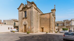 Un bâtiment historique doté d’une entrée imposante, d’un clocher et surplombant un ciel dégagé.