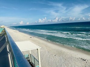 A beach with a clear view of the ocean, a sandy shore, and a pier extending into the water. - Fontaine Retreat 205-Gulf Getaway-Sleeps 3 (Panama City Beach)