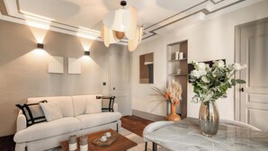 A modern living room with a sofa, coffee table, and a vase of flowers. - 1523 Verneuil (Paris)
