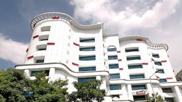 A multi-story building with a curved facade, large windows, and a prominent red stripe.