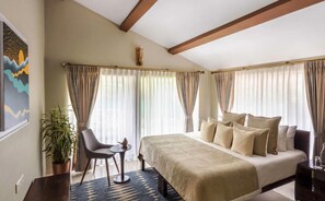 A bedroom with a bed, a chair, a small table, and a potted plant. - Ama Stays & Trails Sluice House, Lonavala (Mawal)