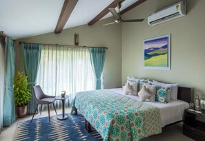 A bedroom with a bed, a chair, a small table, a potted plant, and a painting on the wall. - Ama Stays & Trails Sluice House, Lonavala (Mawal)