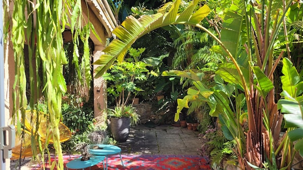 A garden pathway with potted plants and a blue table. - Exceptional garden level pool cap d'antibes (Antibes)