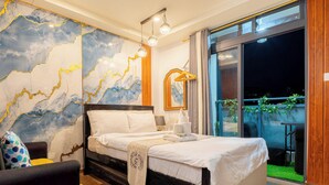 Un dormitorio con cama, una silla, una mesita de noche, un mural con un mapa y un balcón con plantas.