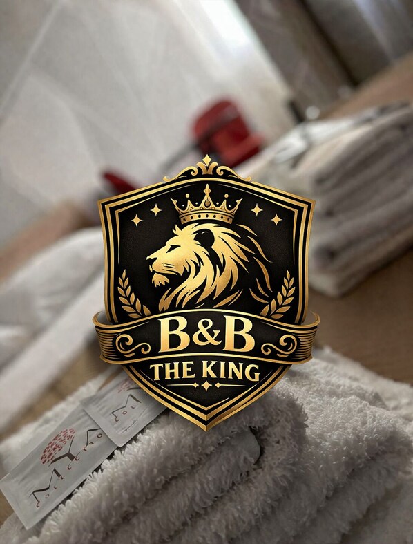 Un logo représentant la tête d’un lion, une couronne et le texte « B&B THE KING » sur un emblème noir et doré.