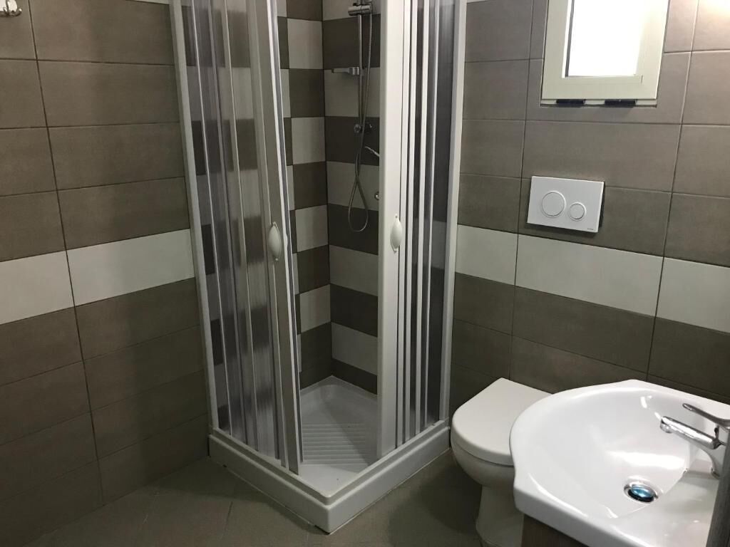 A bathroom with a shower, toilet, and sink.