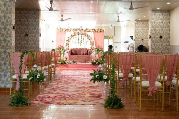 A room with a stage, chairs, and a carpeted floor.