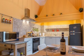 Eine kleine Küche mit Mikrowelle, Herd, Backofen und Kühlschrank.