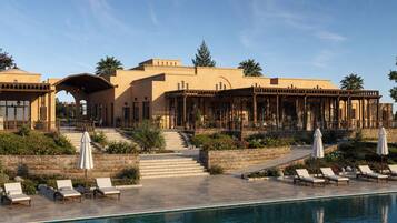 A resort with a pool, lounge chairs, and a covered outdoor area.