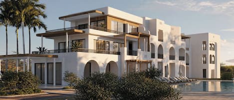 Un edificio moderno de varios pisos con balcones, piscina y palmeras.